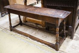 A 17th century style oak long stool, with solid seat on turned legs, length 119cm, depth 28cm,