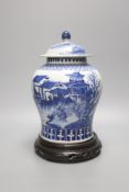 A late 19th / early 20th century Chinese blue and white landscape jar and cover, wood stand 30cm
