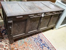 An early 18th century oak coffer, with four panel top and later carved and applied decoration, width