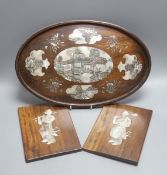 A Chinese hardwood and mother of pearl inlaid oval tray, 43cm and a similar pair of panels decorated