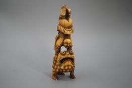 A 19th century Chinese or Japanese carved walrus ivory figure of Liu Hai balancing on his three