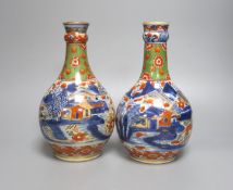 A pair of 18th century Chinese clobbered blue and white bottle vases 23cm