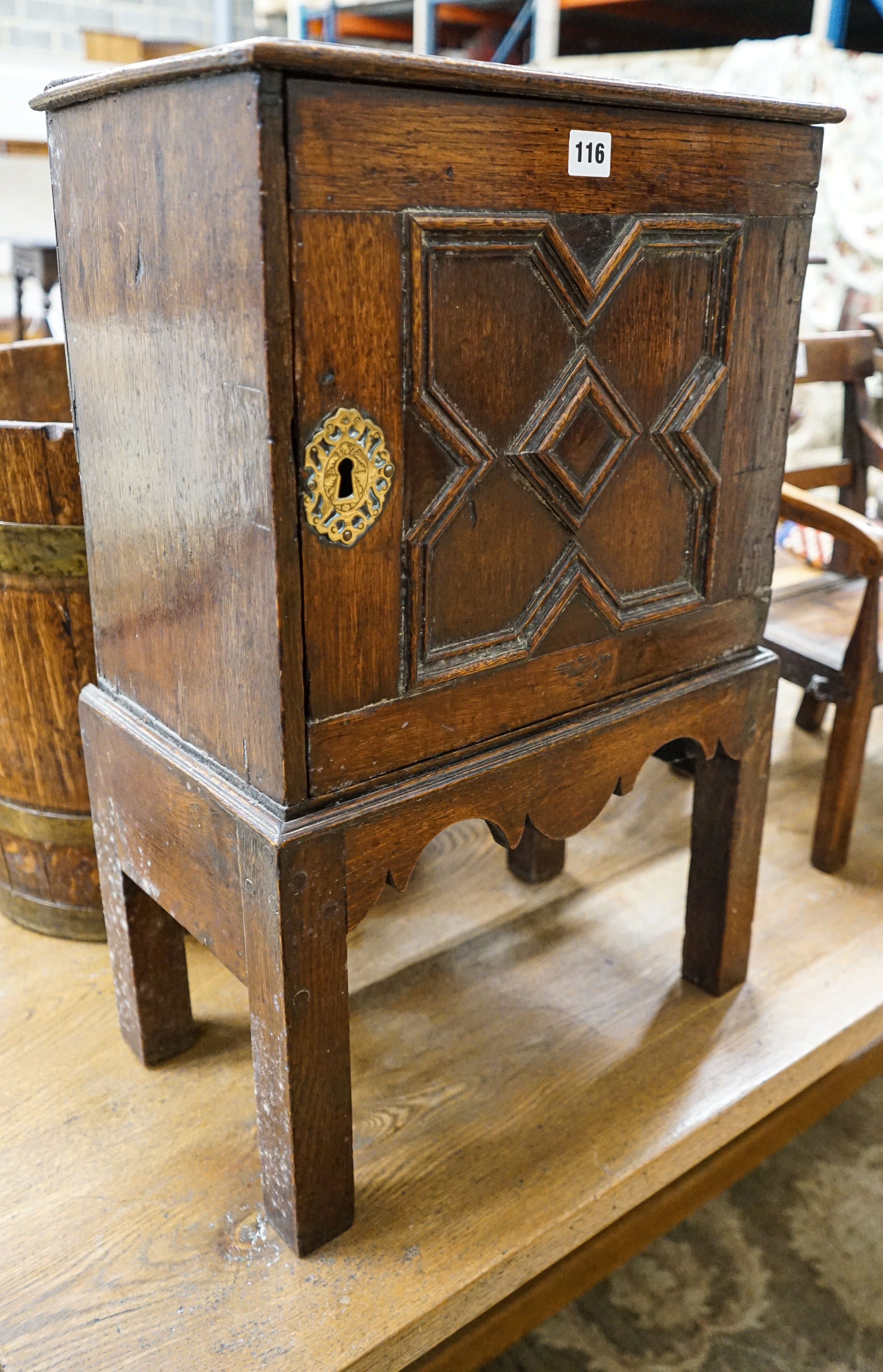 A late 17th century oak spice cupboard, with geometric panelled door enclosing five small drawers,