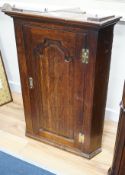 An 18th century panelled oak hanging corner cabinet, width 66cm, depth 43cm, height 93cm