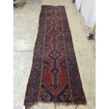 An antique Caucasian red ground runner, 380 x 100cm