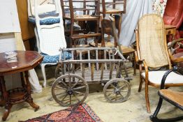 A Victorian oak and beech framed child's cart, with iron bound spoked wheels, length 104cm, depth