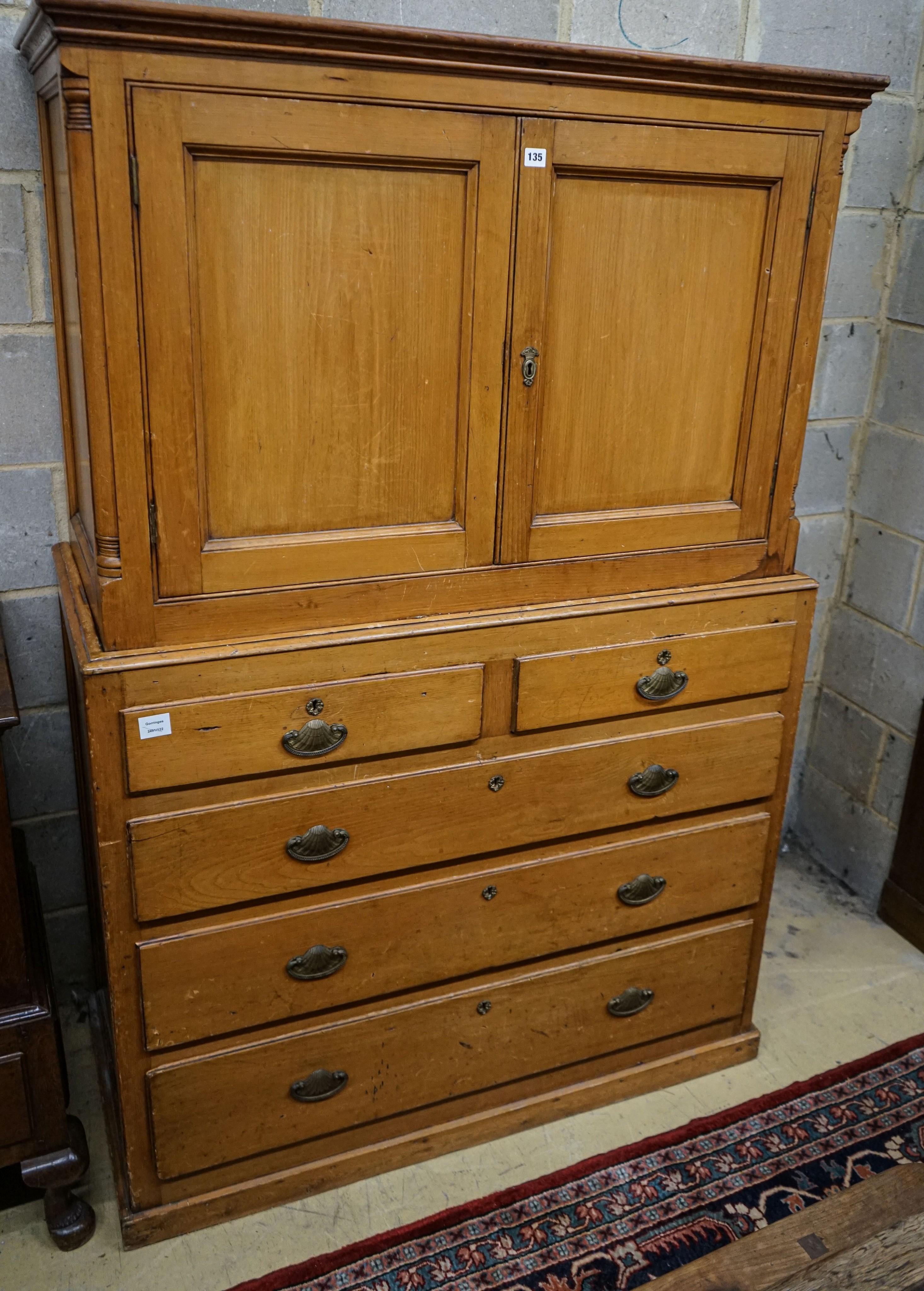 An early Victorian pine kitchen cabinet, with two panelled doors over two short and three long