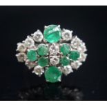 A 20th century 18ct white metal, emerald and diamond set cluster dress ring, size O/P, gross