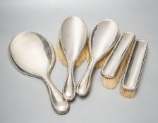 An early 20th century matched five piece silver mounted mirror and brush set.