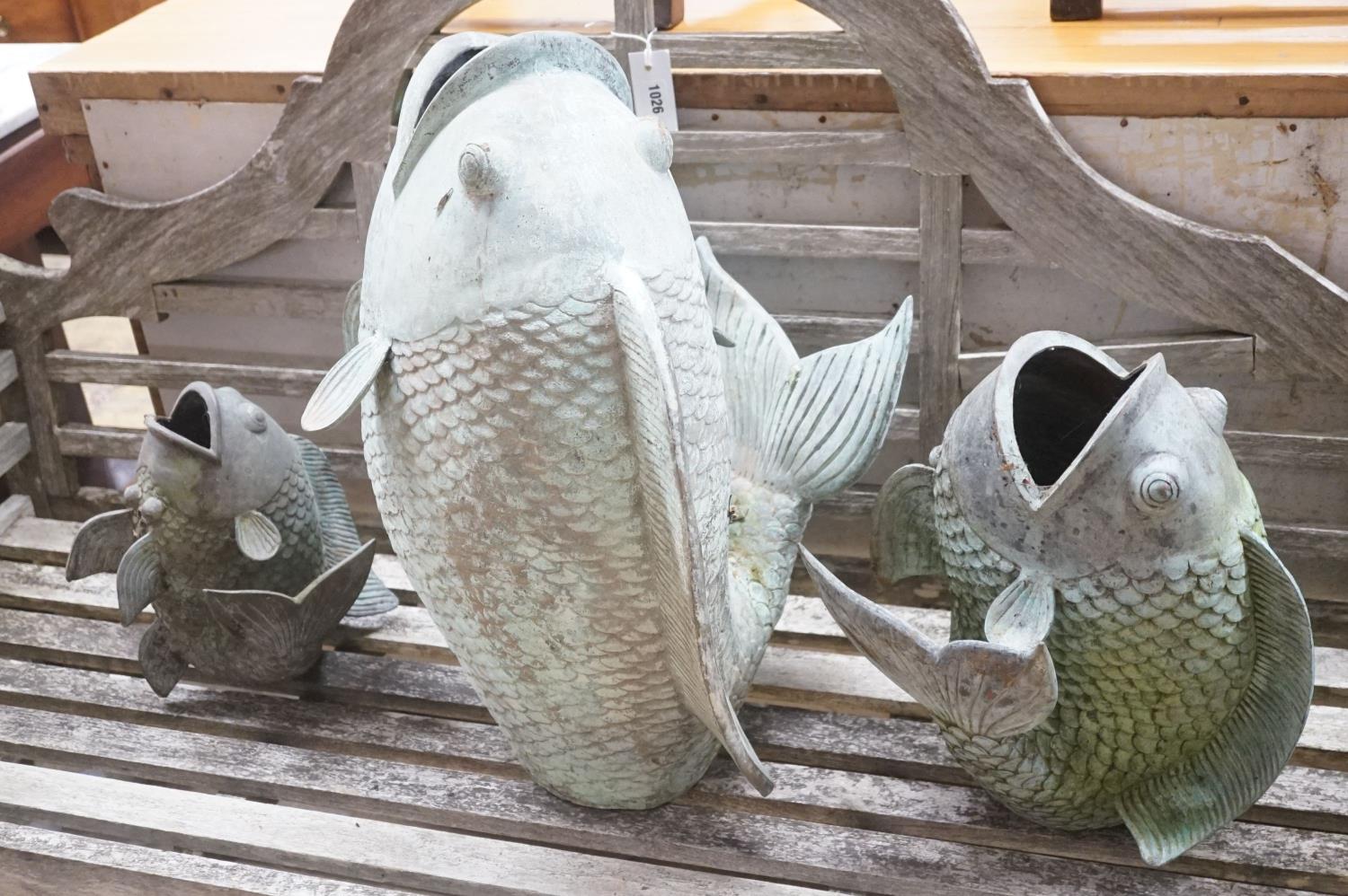 Three cast metal carp garden ornaments, largest 60cm height 46cm