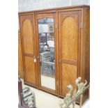 A late Victorian aesthetic movement walnut triple wardrobe, width 187cm depth 56cm height 203cm