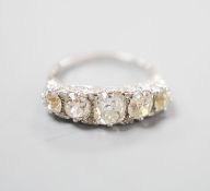 A white metal and graduated five stone old cut diamond set half hoop ring, with diamond chip