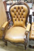A Victorian carved walnut spoonback open armchair, upholstered in buttoned brown leather, width 69cm