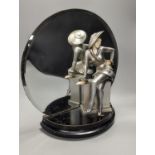 An Art Deco style patinated spelter and faux ivory figural mantel mirror, 31cm