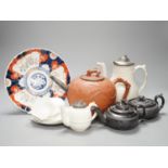 Four 19th century black basalt or black glazed pottery teapots, a large red ware teapot, a creamware