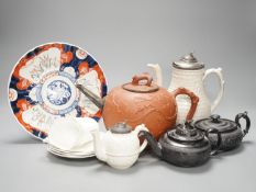 Four 19th century black basalt or black glazed pottery teapots, a large red ware teapot, a creamware