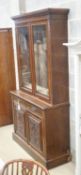 A late Victorian carved walnut bookcase, width 120cm depth 43cm height 220cm