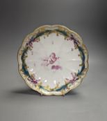 A Chelsea-Derby circular dish painted in puce with a cherub floating on a cloud by Richard Askew,