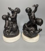 A pair of bronze figure groups, trio of putto, on white marble plinths, tallest 26cm