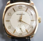 A gentleman's 9ct. gold wristwatch by Garrard in cushion case, silvered dial, baton and Roman