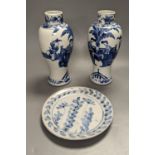 A pair of Chinese figural blue and white vases, drilled bases, height 25cm, and a plate