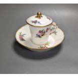 A Sevres tapering cup with entwined handle and cover and stand painted with flowers, date code for