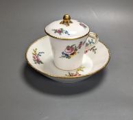 A Sevres tapering cup with entwined handle and cover and stand painted with flowers, date code for