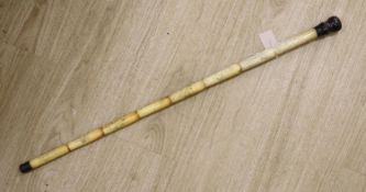 A Chinese engraved bone walking cane, 84cm