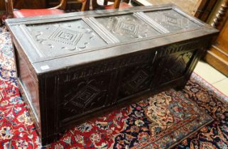 A late 17th/early 18th century carved and panelled oak coffer with hinged lid, width 136cm, depth