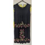 A an unusual 1920's black , georgette, beaded dress, embroidered with multicoloured and jet beads,