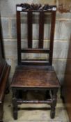 A late 17th century oak back stool, with carved cresting rail, slatted back and solid seat, on