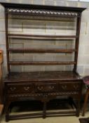 A mid 18th century oak dresser, with pierced cornice and three shelf rack over three drawers, with