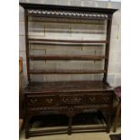 A mid 18th century oak dresser, with pierced cornice and three shelf rack over three drawers, with