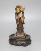 A 19th century Chinese soapstone figure of He Xiangu, associated wood stand 19cm