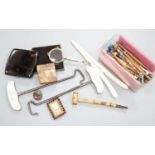 A collection of bone and wooden lace bobbins, ivory glove stretchers, boot hooks, compacts and mixed