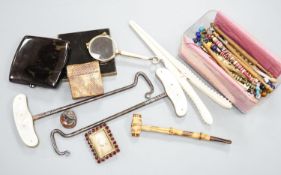 A collection of bone and wooden lace bobbins, ivory glove stretchers, boot hooks, compacts and mixed