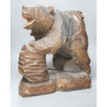 A large Japanese carved wooden bear holding a fish, inscribed 47cm