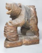 A large Japanese carved wooden bear holding a fish, inscribed 47cm
