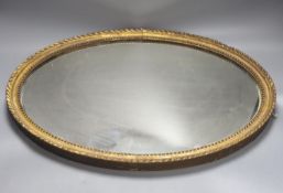 An oval gilt framed wall mirror, 55.5 cm high