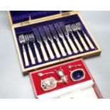 A cased modern silver three piece condiment set, a cased set of twelve Edwardian silver teaspoons,