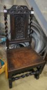 A 17th century oak dining chair, with carved panelled back, solid seat and barley twist