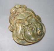 A green hard stone mask carving, height 21cms