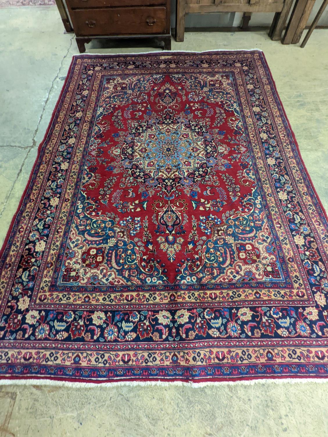 A Tabriz burgundy ground carpet, 350 x 250cm