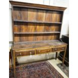 A George III oak dresser, with two shelf rack and three long drawers, on chamfered legs, width