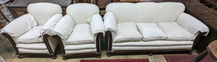 An early 20th century carved mahogany upholstered three piece lounge suite on claw and ball feet,
