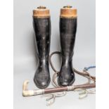 A pair of black leather riding boots with trees, a silver mounted whip and spurs