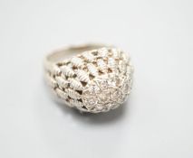 A continental textured white metal and diamond cluster set domed top dress ring, size K/L, gross