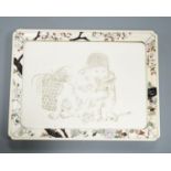 A Japanese ivory tray/plaque, Meiji period, with sunk-in carving of boy with dove, the surround