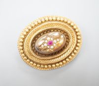 A Victorian yellow metal, ruby? and seed pearl set oval brooch, with glazed back, 43mm, gross weight