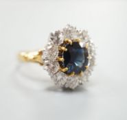 A modern 18ct gold, sapphire and diamond set oval cluster ring, size P/Q, gross weight 6.2 grams.